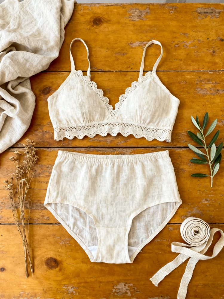 Conjunto de lingerie bege com soutien de renda e cueca de cintura alta sobre mesa de madeira