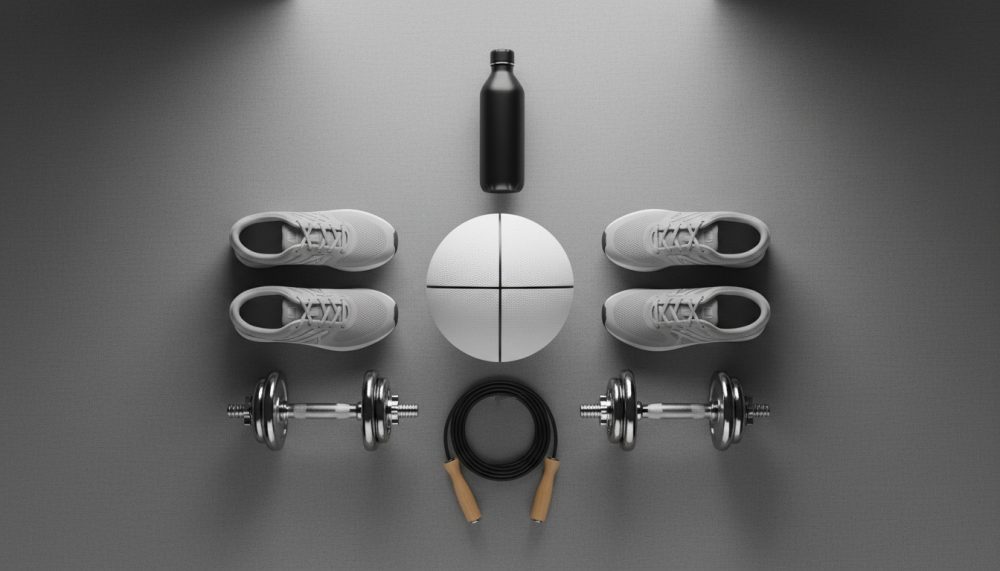 Equipamento desportivo organizado com sapatilhas, halteres, bola, corda de saltar e garrafa de água