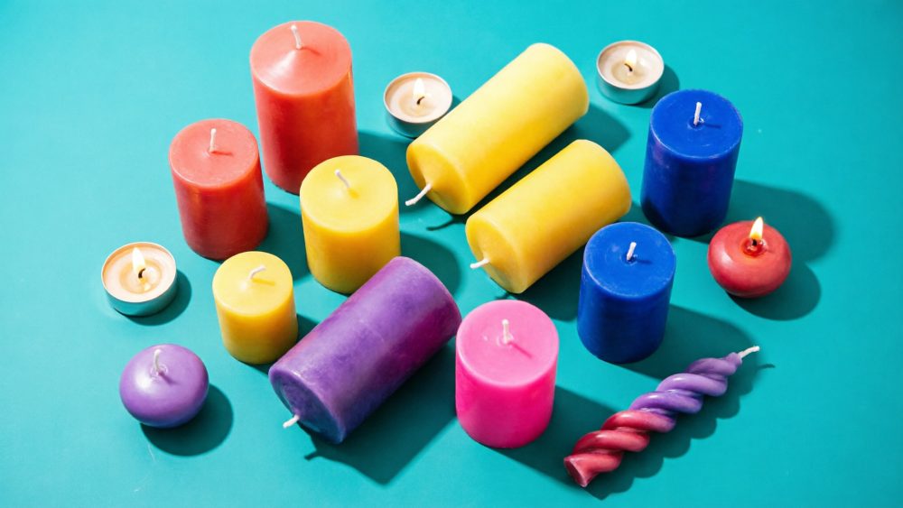 Velas coloridas de vários tamanhos e formas sobre fundo azul
