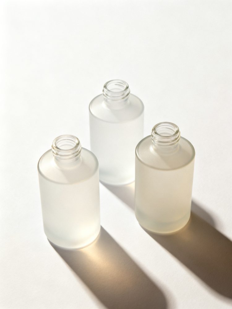 Três frascos de vidro fosco sem tampa com sombras longas em fundo branco