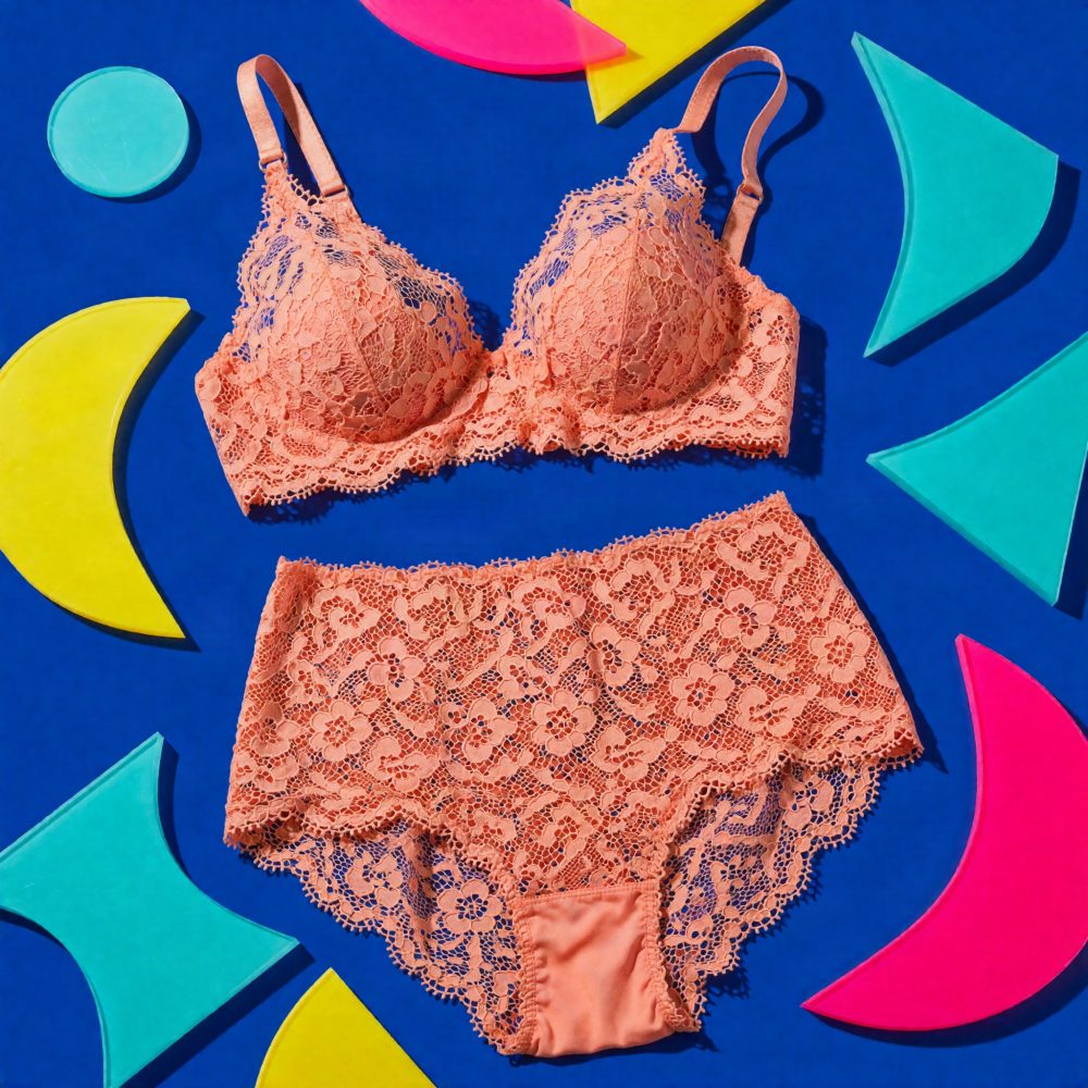 Conjunto de lingerie salmão em renda floral exibido sobre fundo azul com formas coloridas