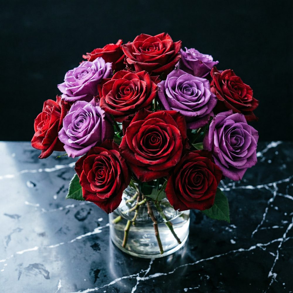 Bouquet de rosas vermelhas e lilases numa jarra de vidro sobre mármore preto