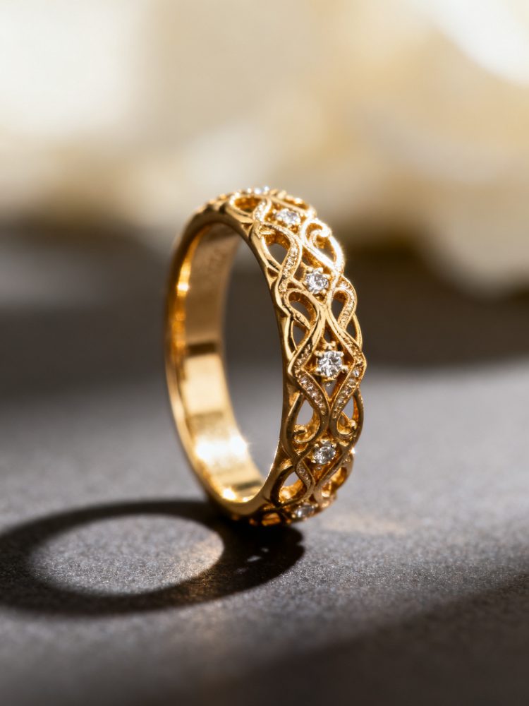 Anel de ouro com padrão entrelaçado e diamantes sobre fundo escuro.
