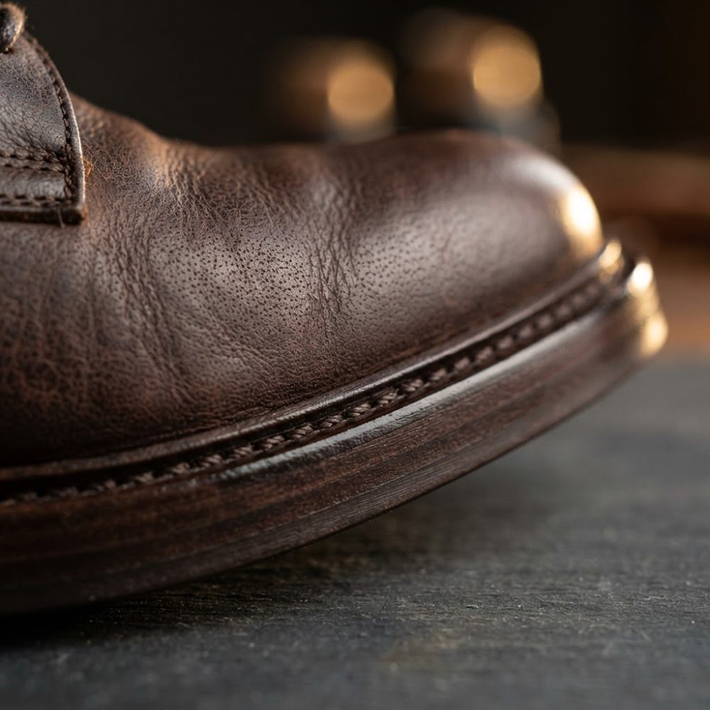 Close-up de sapato masculino em pele castanha com detalhes em costura