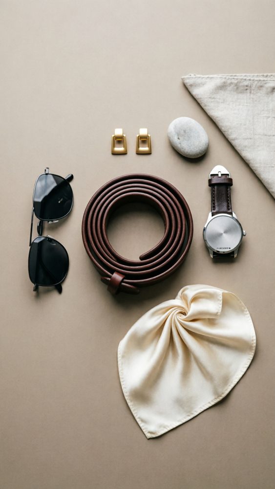 Conjunto de acessórios de moda com cinto castanho, relógio, óculos escuros, brincos dourados e lenço claro