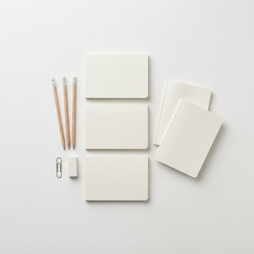 Conjunto de papelaria pronto com cadernos, blocos, lápis, borracha e clip em fundo branco