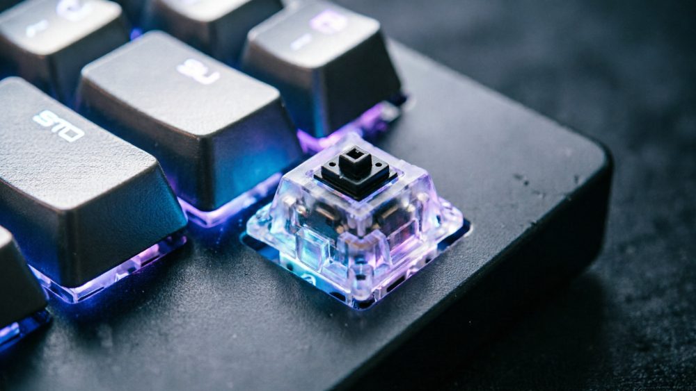 Close-up de tecla mecânica iluminada num teclado gaming preto