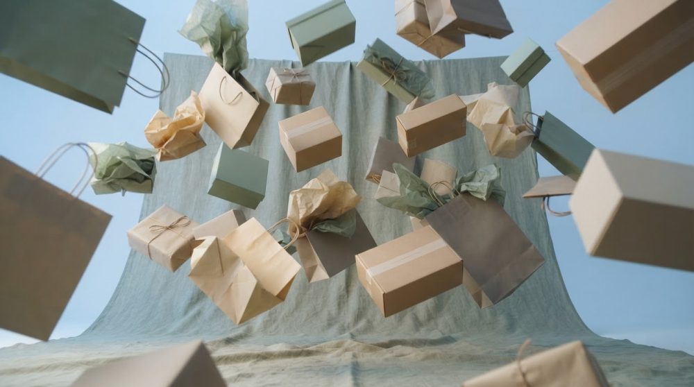 Sacos e caixas de papel reciclado a caírem contra fundo azul suave, conceito sustentável para Black Friday.