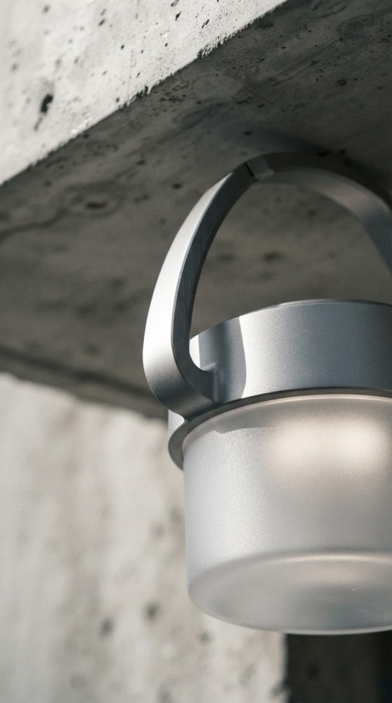 Lanterna portátil cinza pendurada em parede de cimento com luz suave