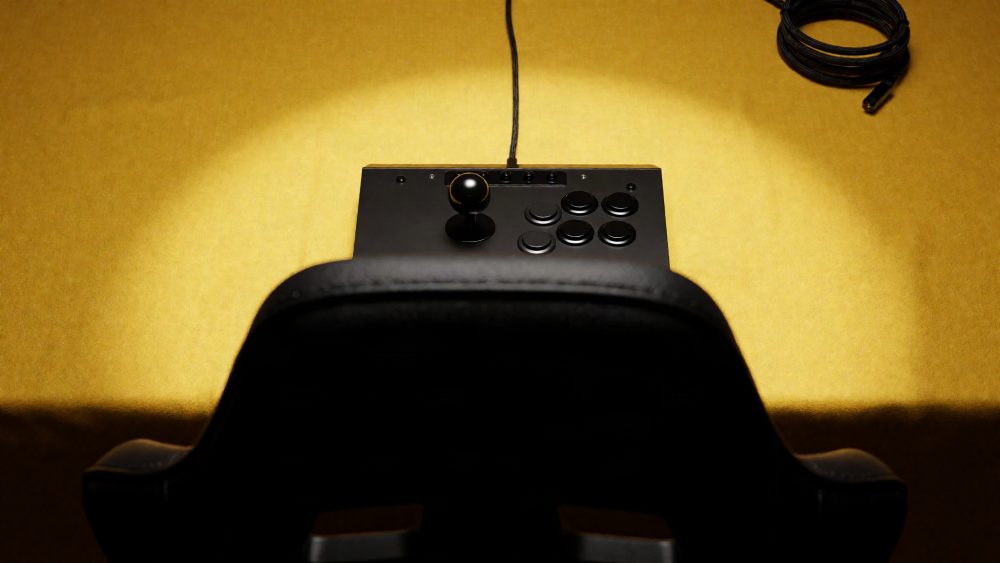 Comando arcade preto com joystick e botões visto de trás sobre superfície amarela