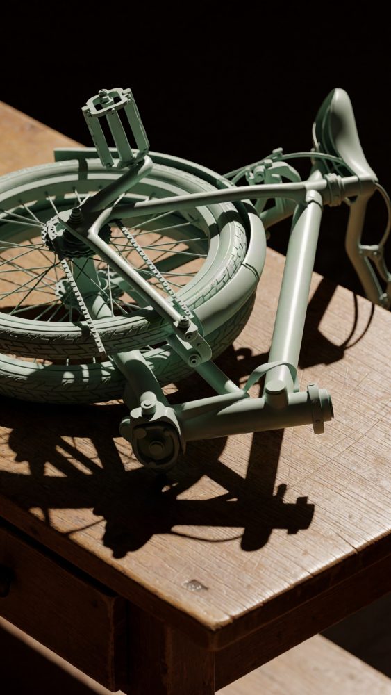 Bicicleta dobrável verde sobre mesa de madeira com luz natural e sombras