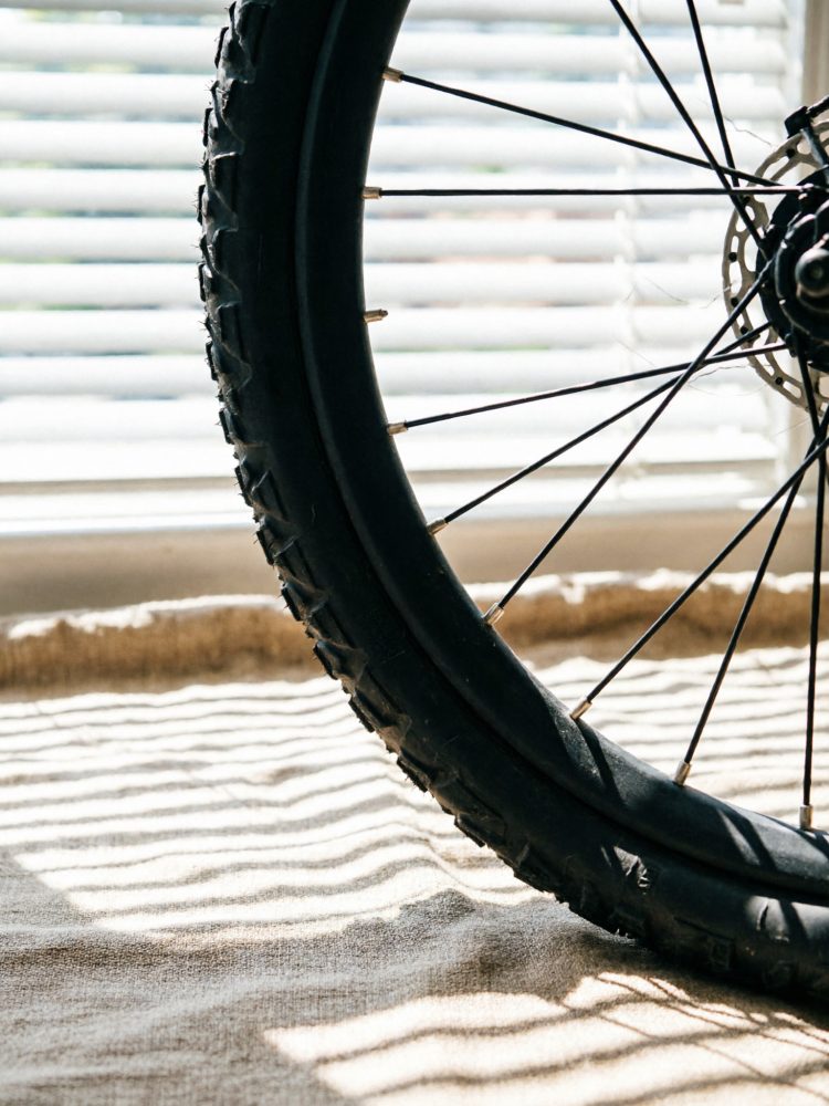 Pneu e raios de roda de bicicleta com sombra de persianas no chão