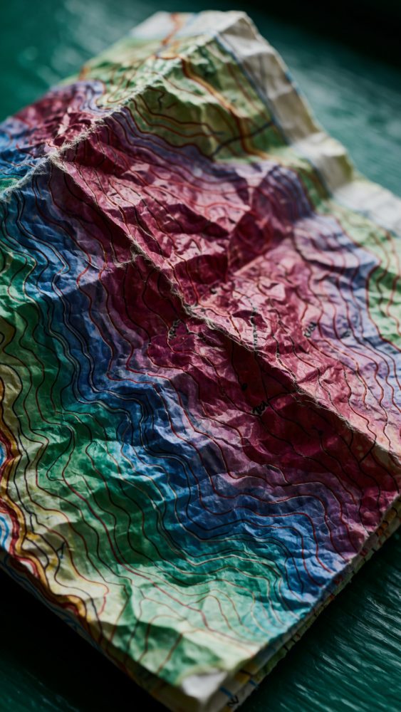 Mapa topográfico dobrado com cores vibrantes e linhas de contorno detalhadas para planeamento de viagem