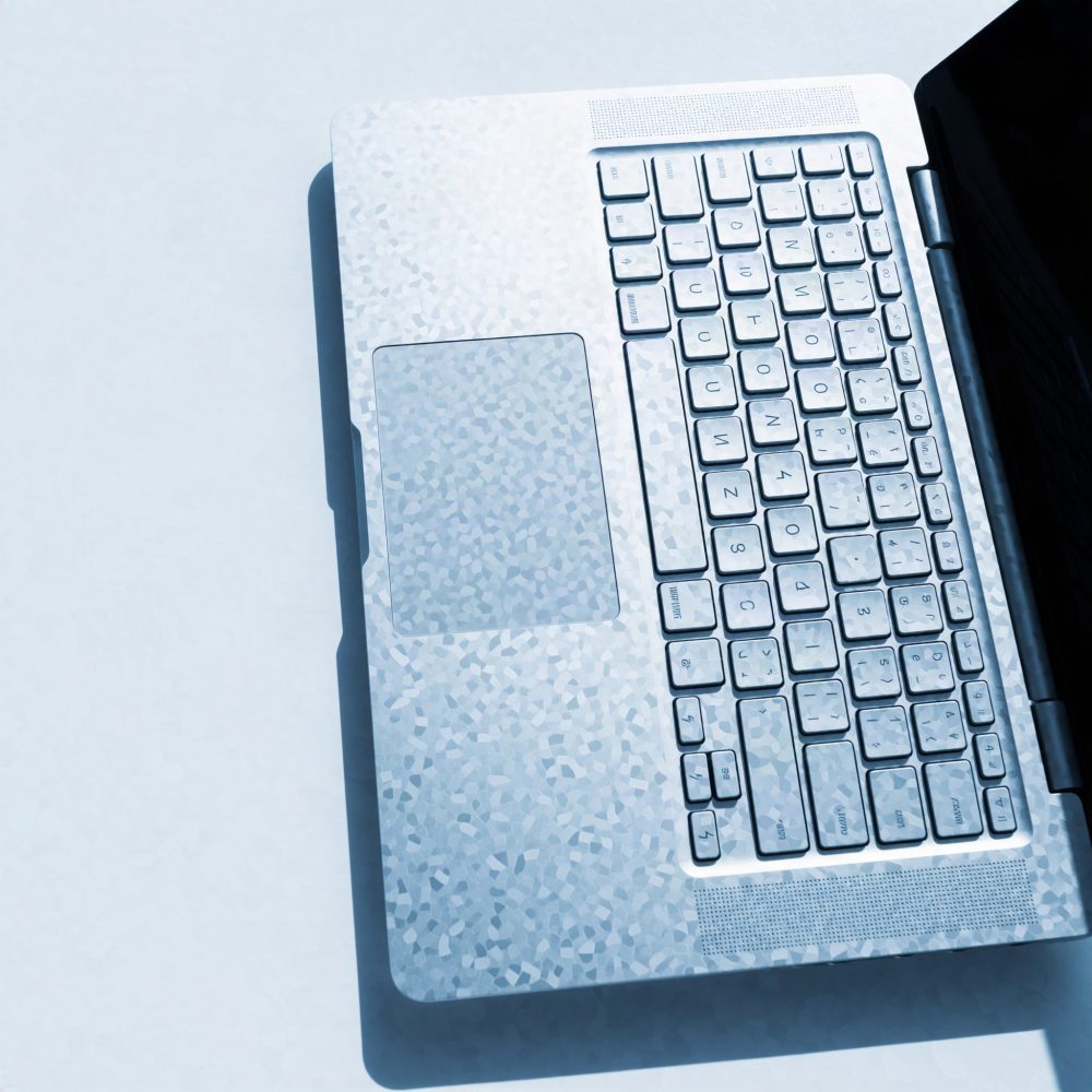 Portátil aberto com teclado retroiluminado azul claro e área do touchpad