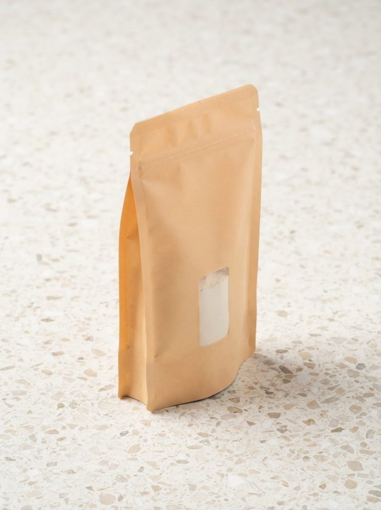 Saco de suplemento em papel kraft com janela transparente sobre superfície clara