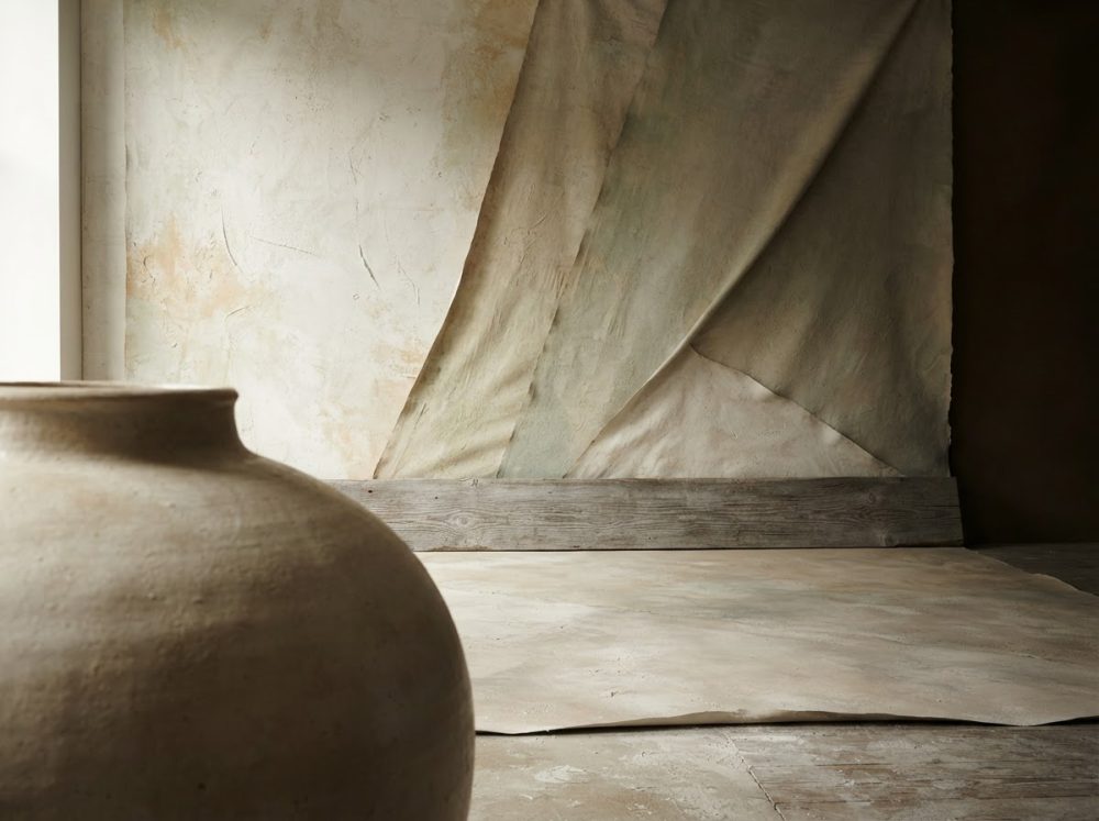 Fundo e superfície rústica texturada neutra com vaso cerâmico grande em primeiro plano