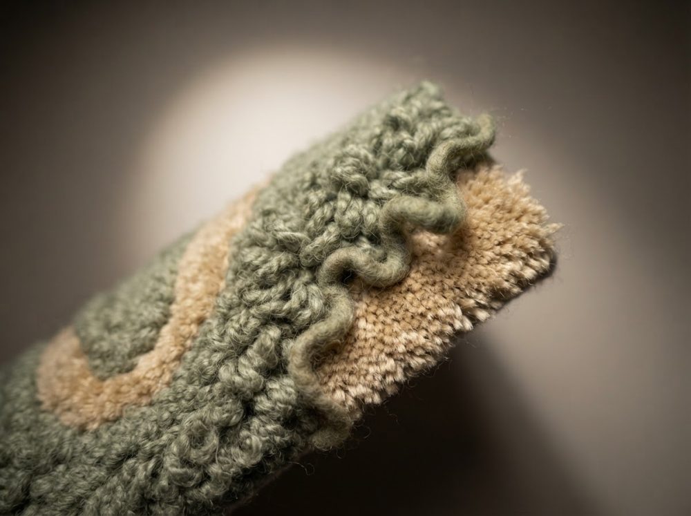 Textura abstrata de tecido verde e bege com padrão ondulado e relevo
