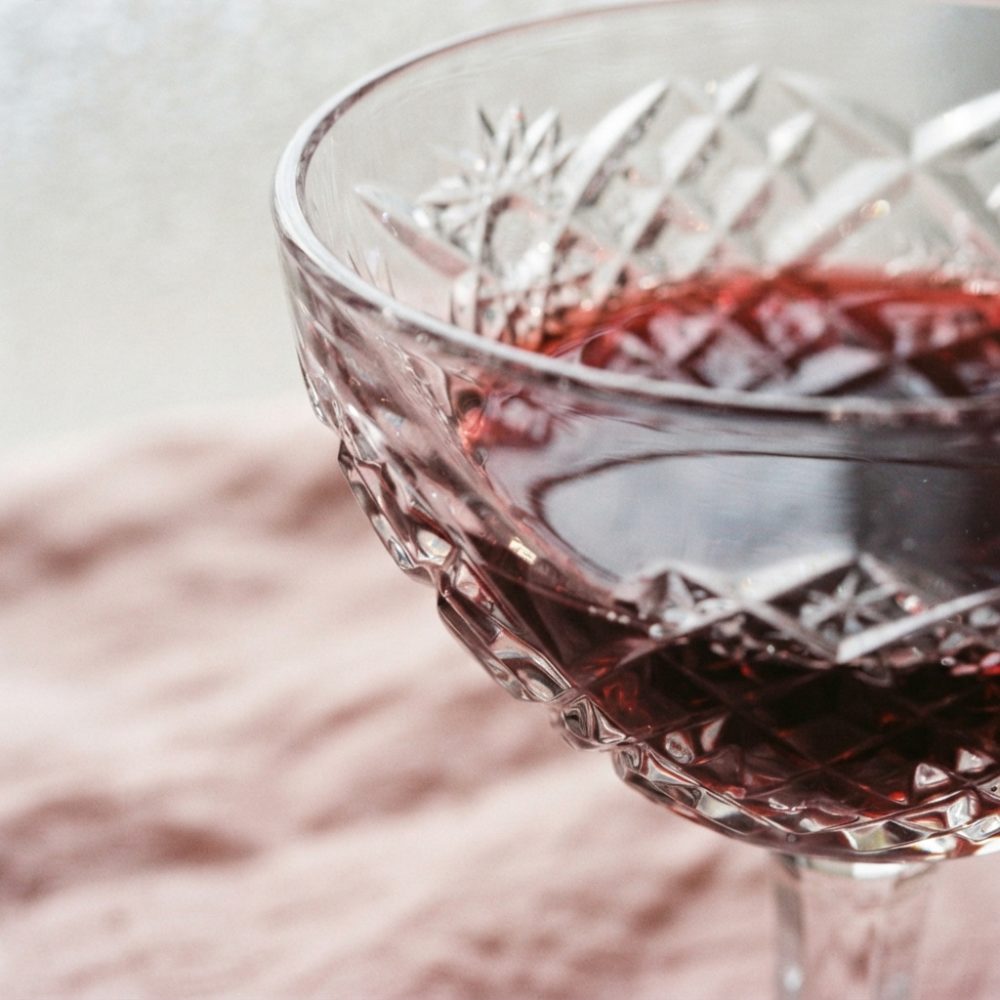 Taça de vidro com vinho tinto sobre superfície texturada