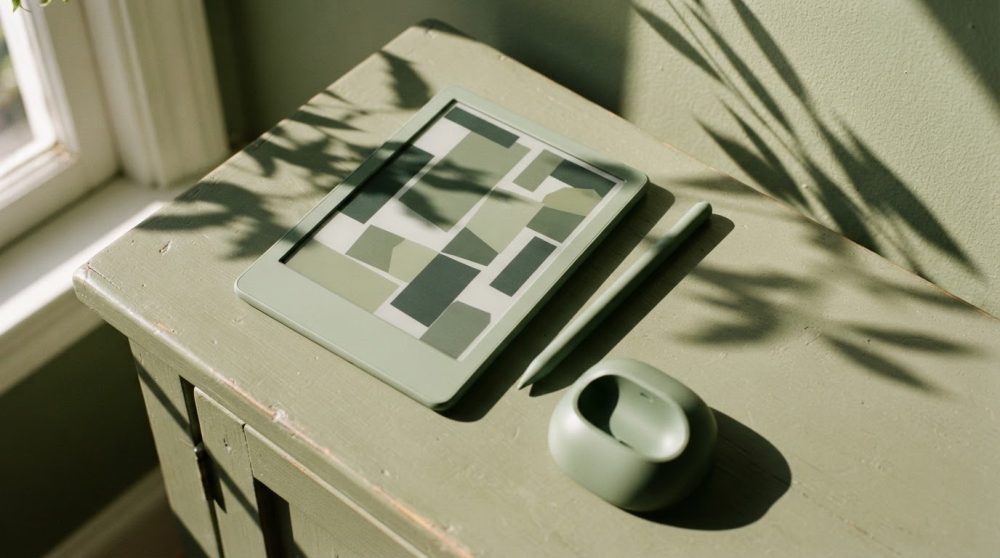 Dispositivos tecnológicos verdes sobre móvel vintage com sombras de plantas ao sol