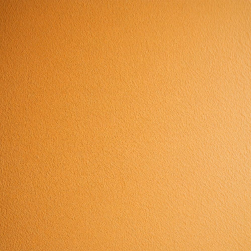 Superfície texturizada de cor laranja vibrante para fundo e decoração