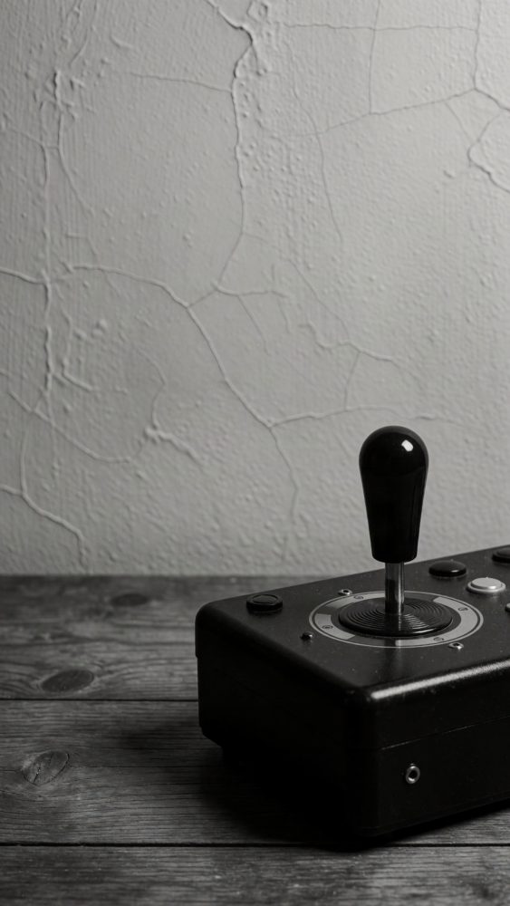 Joystick preto clássico vintage sobre mesa de madeira com parede texturizada ao fundo