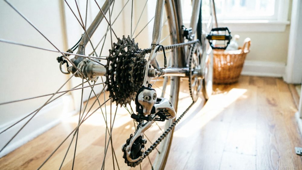 Transmissão traseira e corrente de bicicleta com luz natural em piso de madeira