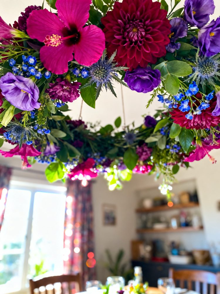 Guirlanda suspensa com flores coloridas em interior iluminado por luz natural