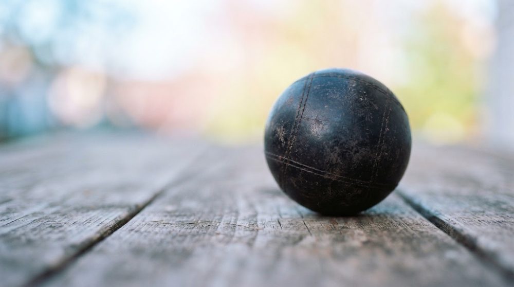 Bola preta de jogo sobre madeira rústica com fundo desfocado