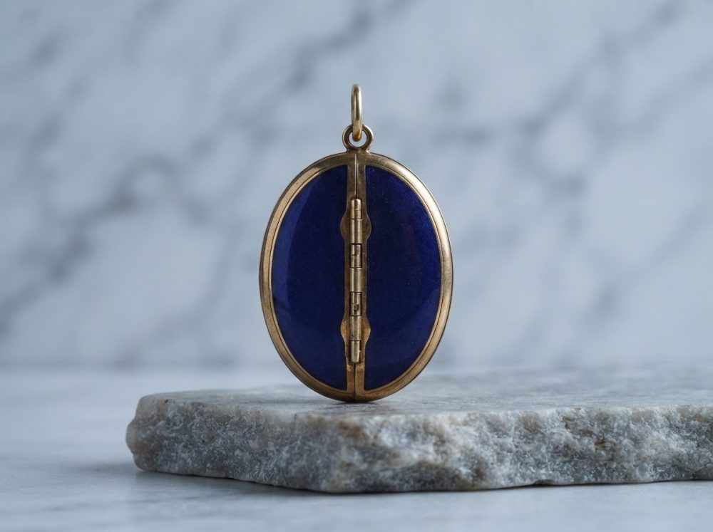 Medalhão oval azul com moldura dourada em suporte de pedra cinzenta com fundo desfocado