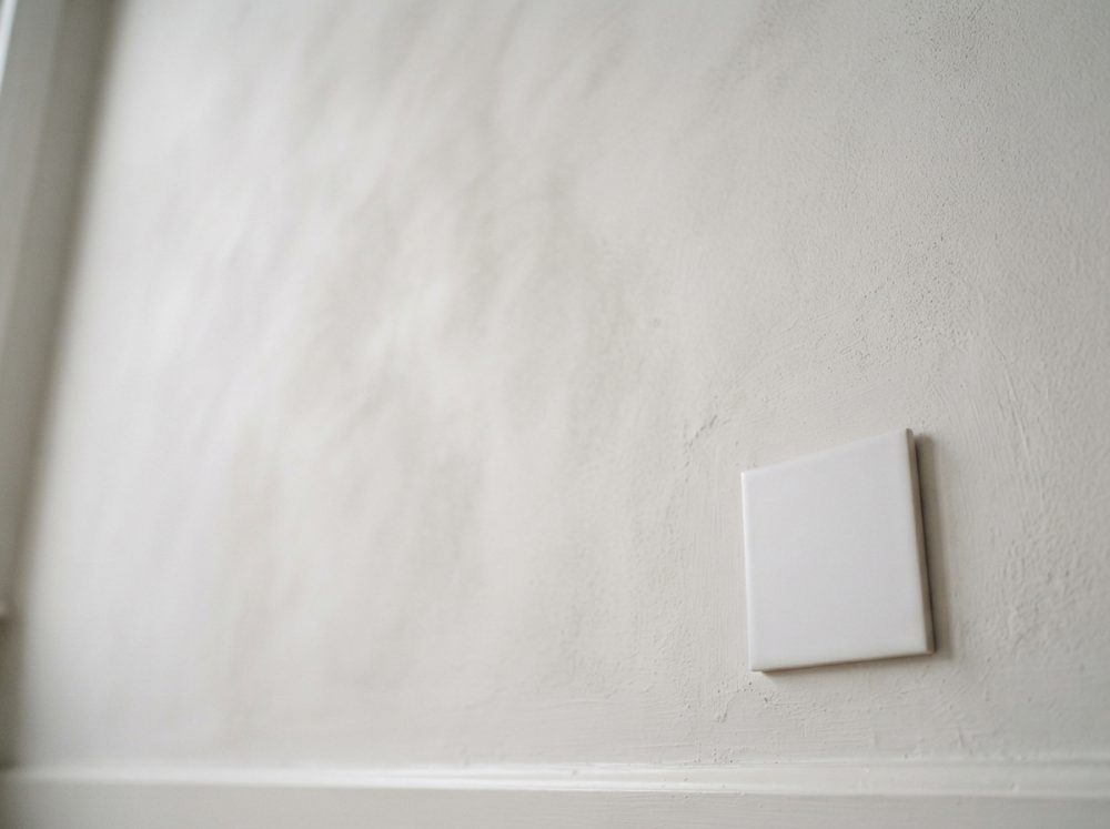 Parede branca com azulejo quadrado em relevo em superfície texturada