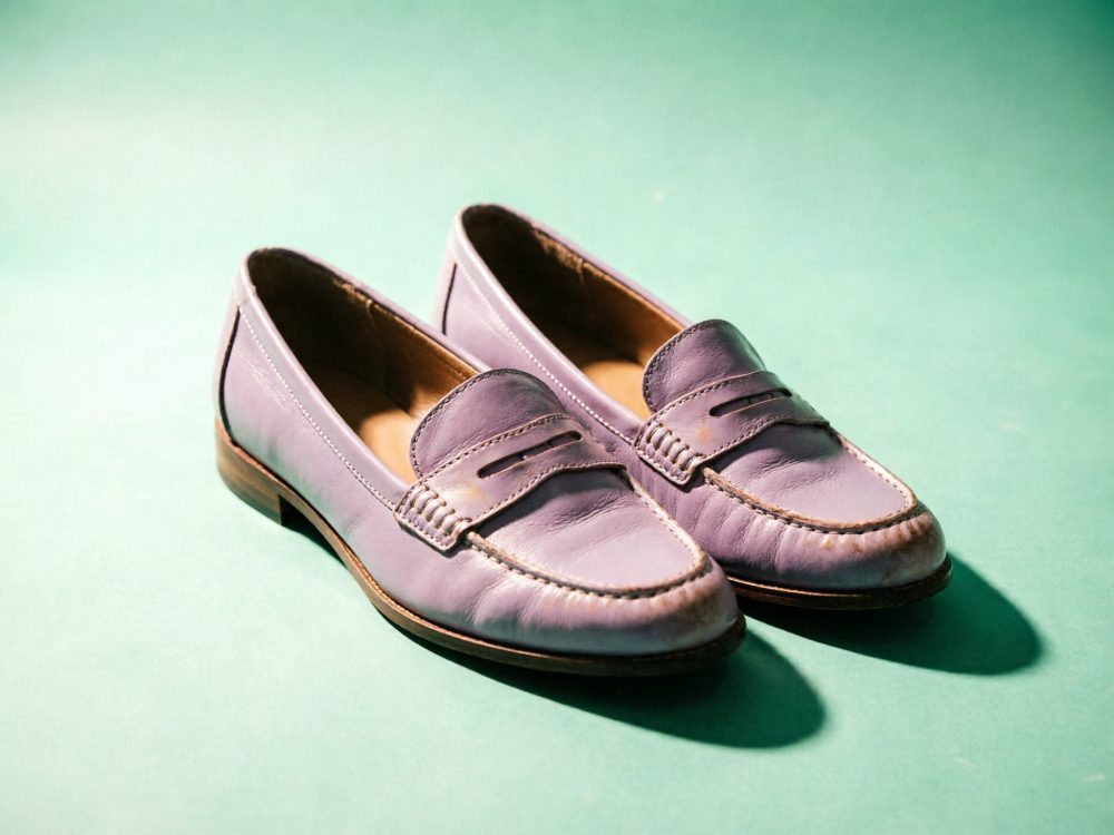 Sapatos mocassim lilás de pele para mulher em fundo verde claro