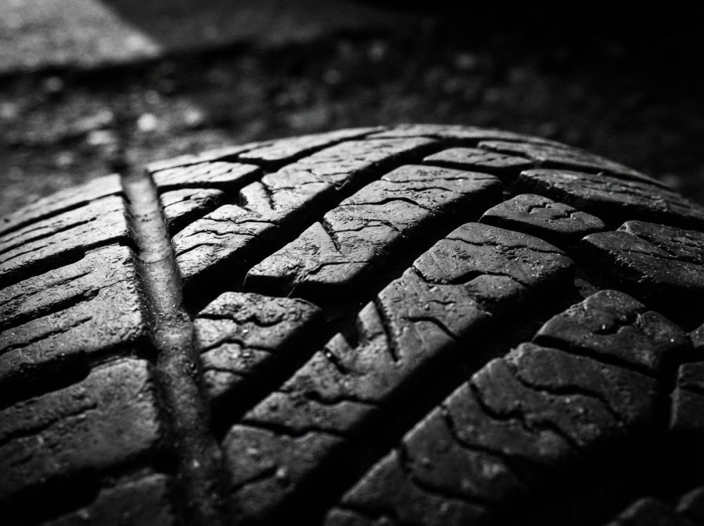 Close-up de pneu de automóvel com padrão de piso detalhado em preto e branco