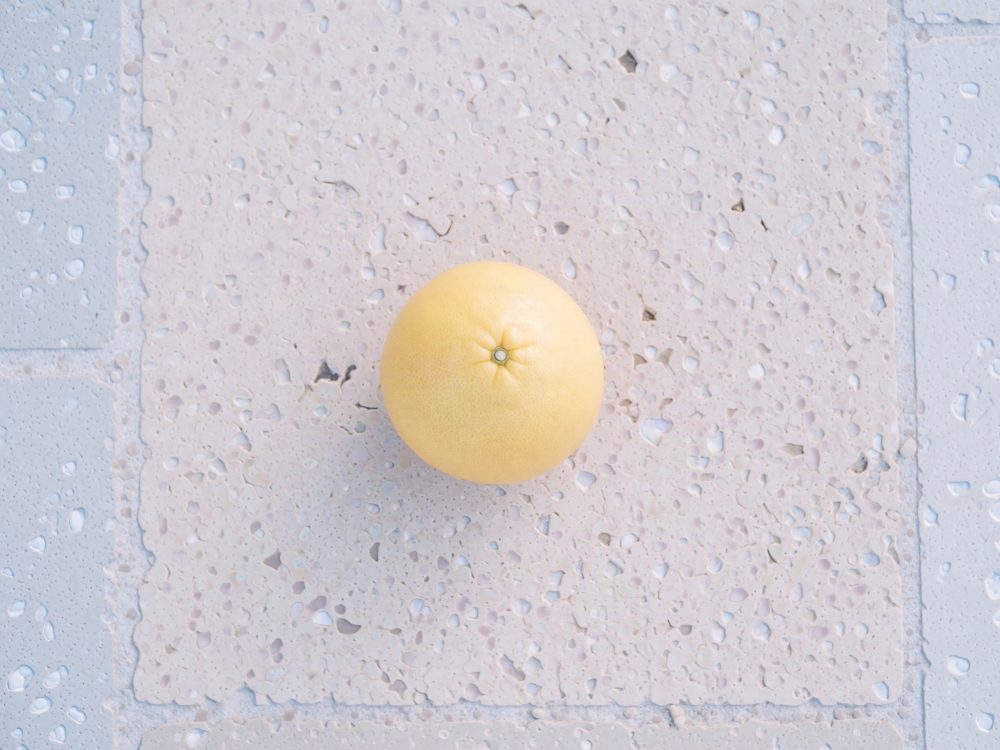 Toranja amarela vista de cima sobre chão claro e texturizado.