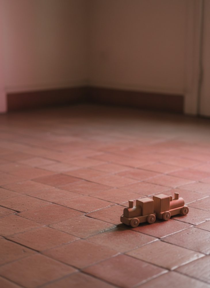 Comboio de brinquedo de madeira vintage no chão de ladrilho vermelho