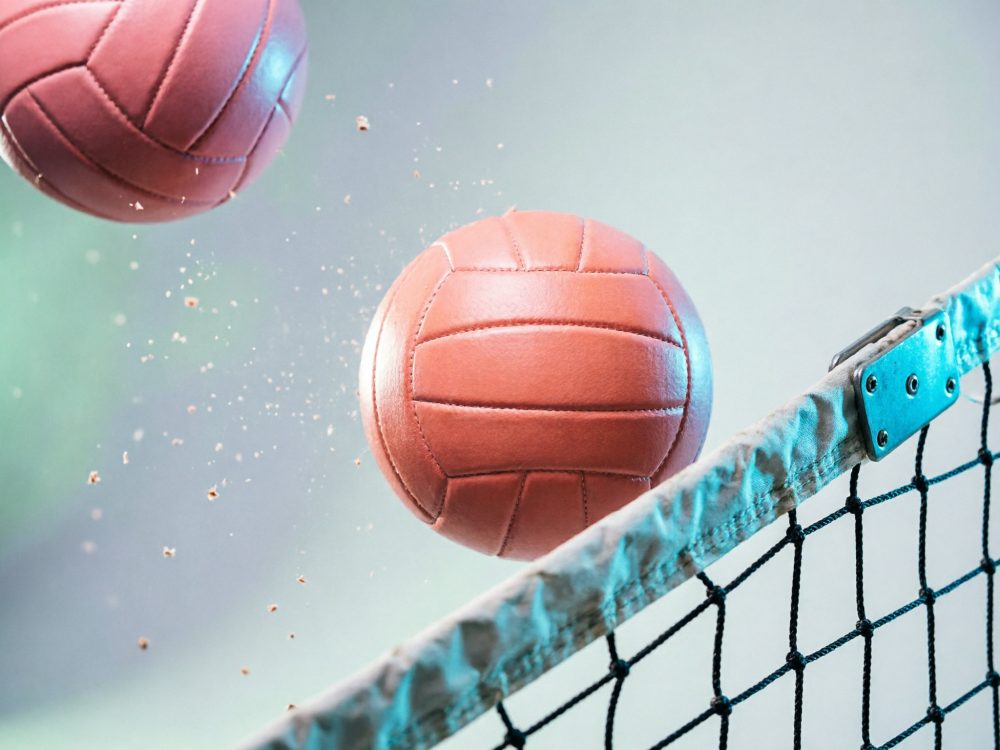 Bolas de voleibol castanhas a passar por uma rede desportiva preta e branca