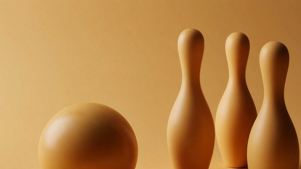 Bola e três pinos de bowling em tons bege com fundo uniforme da mesma cor