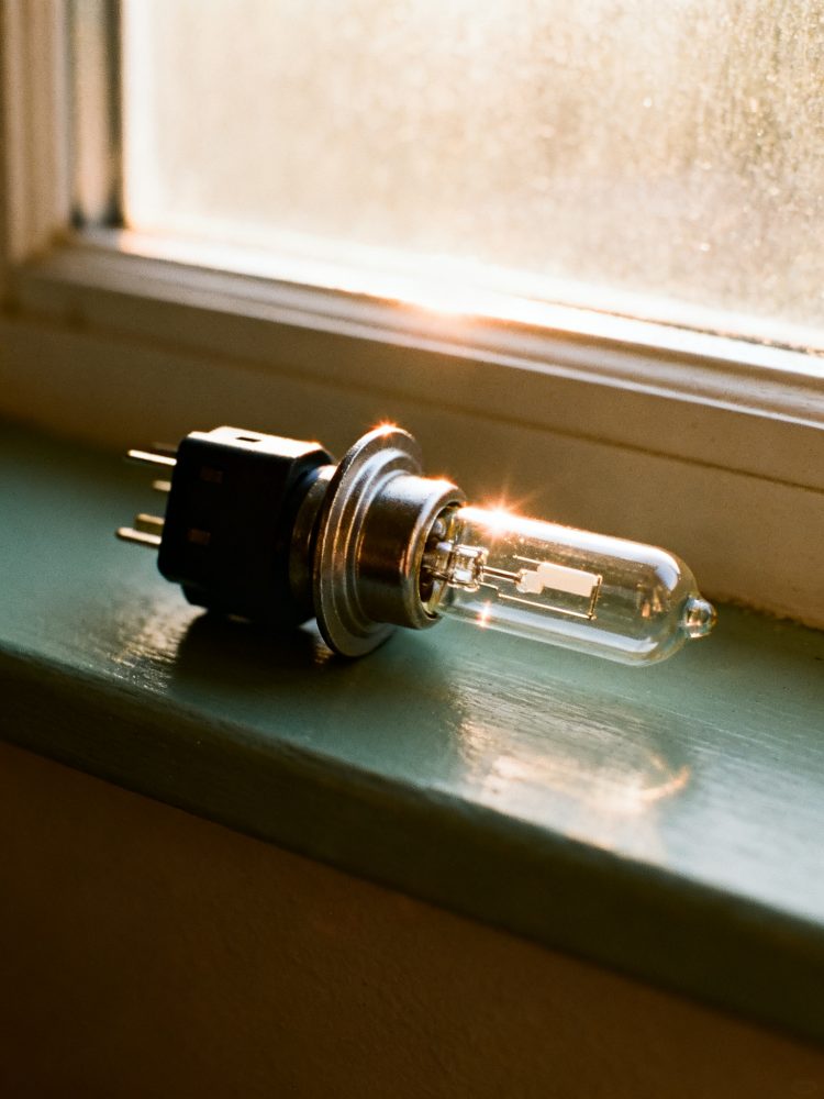 Lâmpada de halogéneo para automóvel sobre peitoril verde com luz natural
