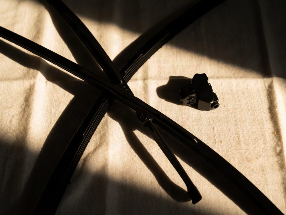 Escovas limpa para-brisas pretas com adaptador sobre tecido claro iluminado