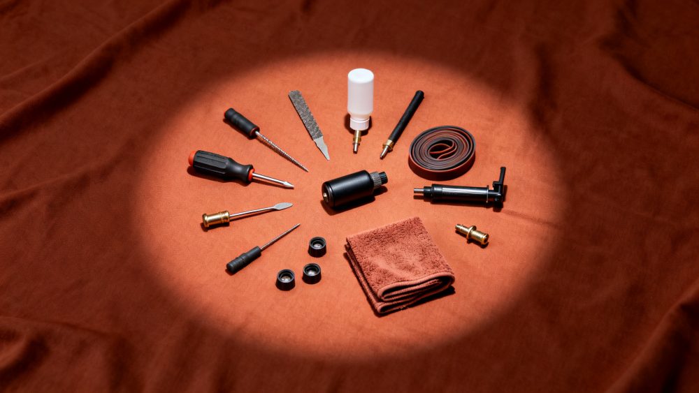 Kit de ferramentas para reparação de pneus automóveis sobre tecido castanho com luz focalizada