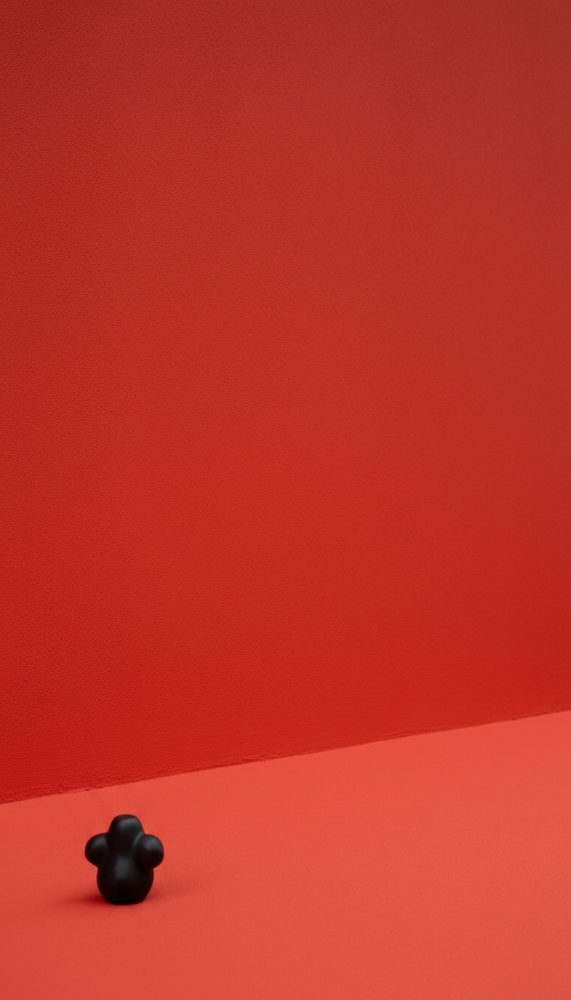 Fundo e superfície vermelhos com textura, pequeno objeto preto na base