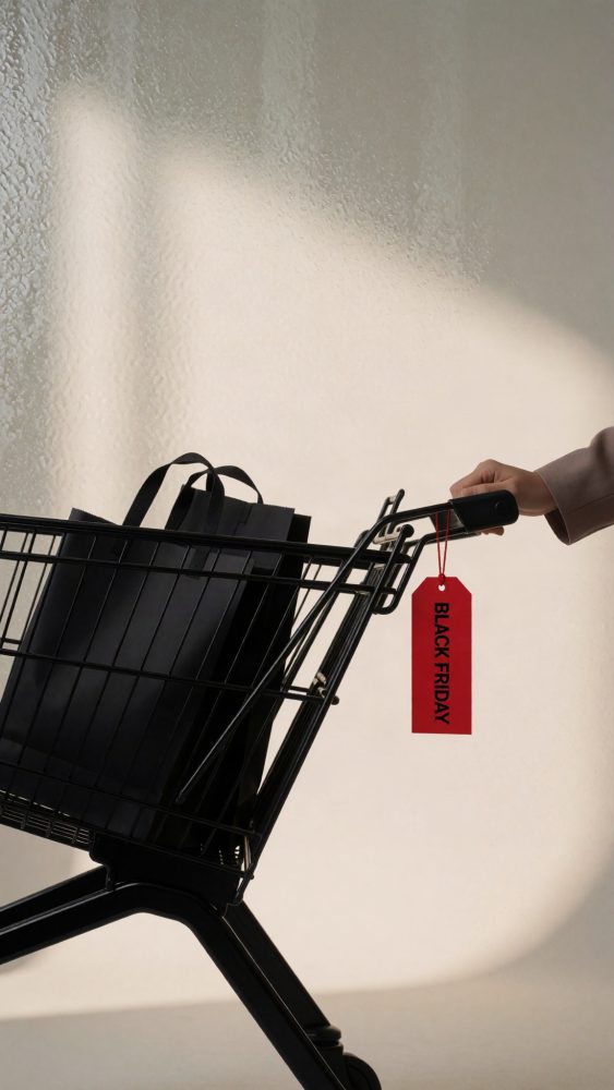 Carrinho de compras preto com sacos escuros e etiqueta vermelha de Black Friday