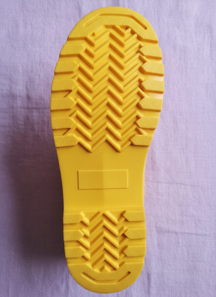 Sola antiderrapante amarela com padrão zig-zag e blocos em relevo para calçado
