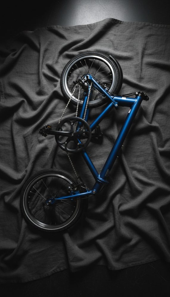 Quadro de bicicleta azul com rodas pretas sobre tecido cinzento escuro