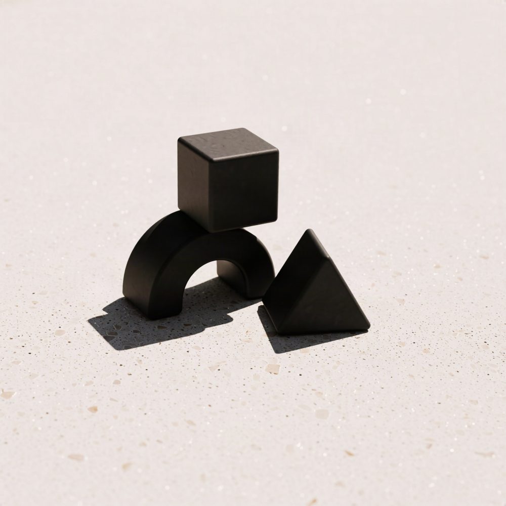 Blocos geométricos pretos de madeira com cubo, arco e pirâmide sobre fundo bege.