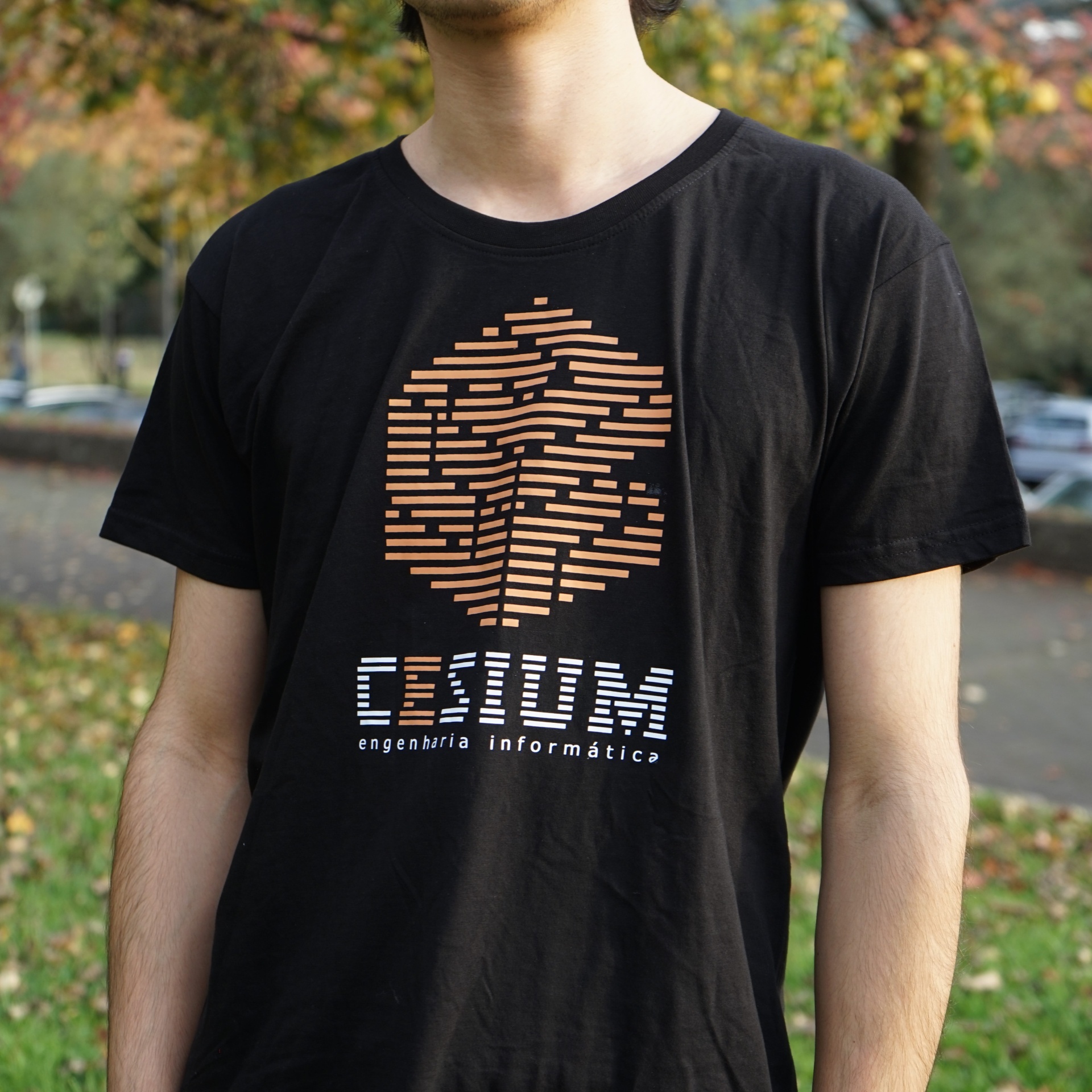T-shirt preta com estampa laranja e texto branco CESIUM engenharia informática ao ar livre