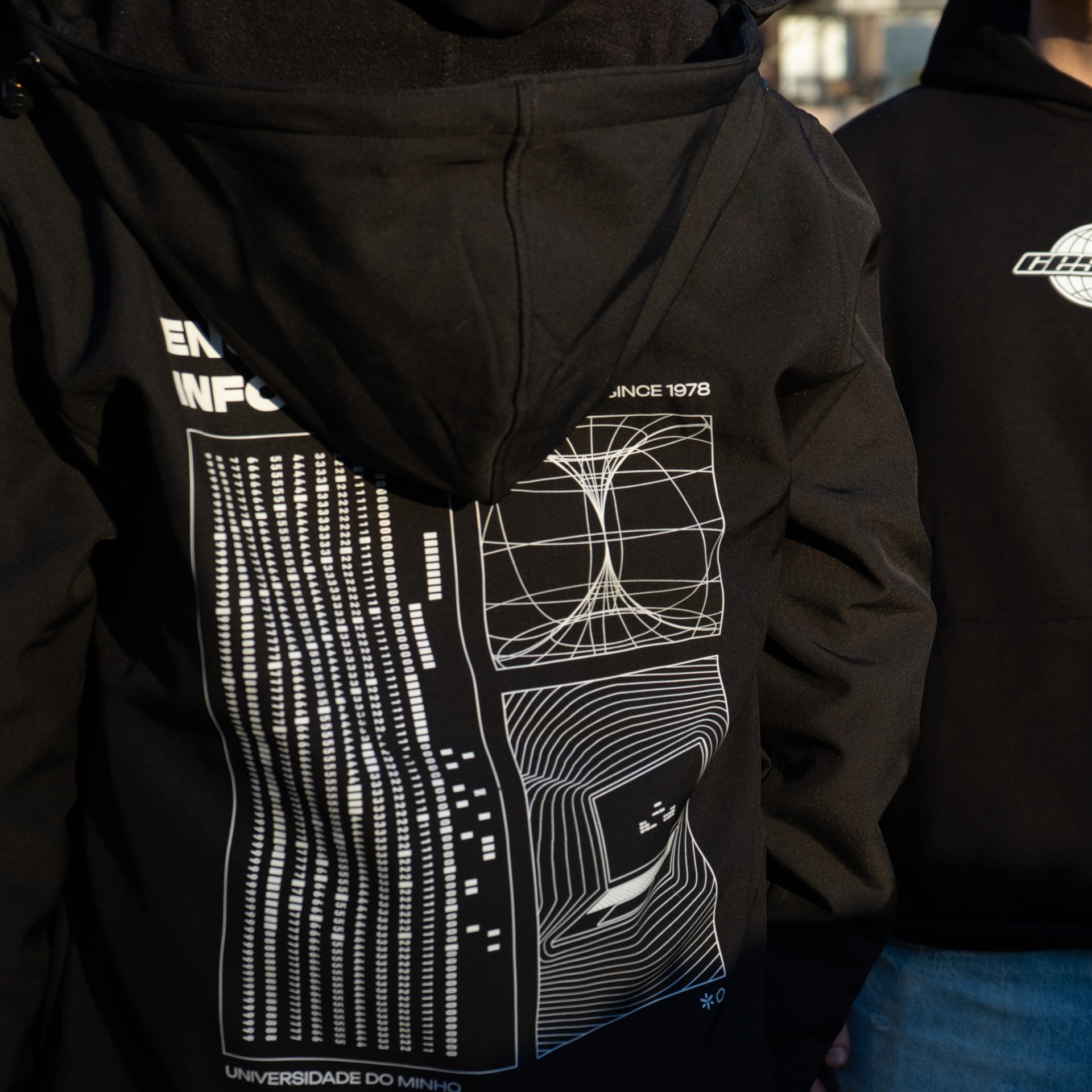 Casaco preto com capuz e estampas brancas de gráficos e texto