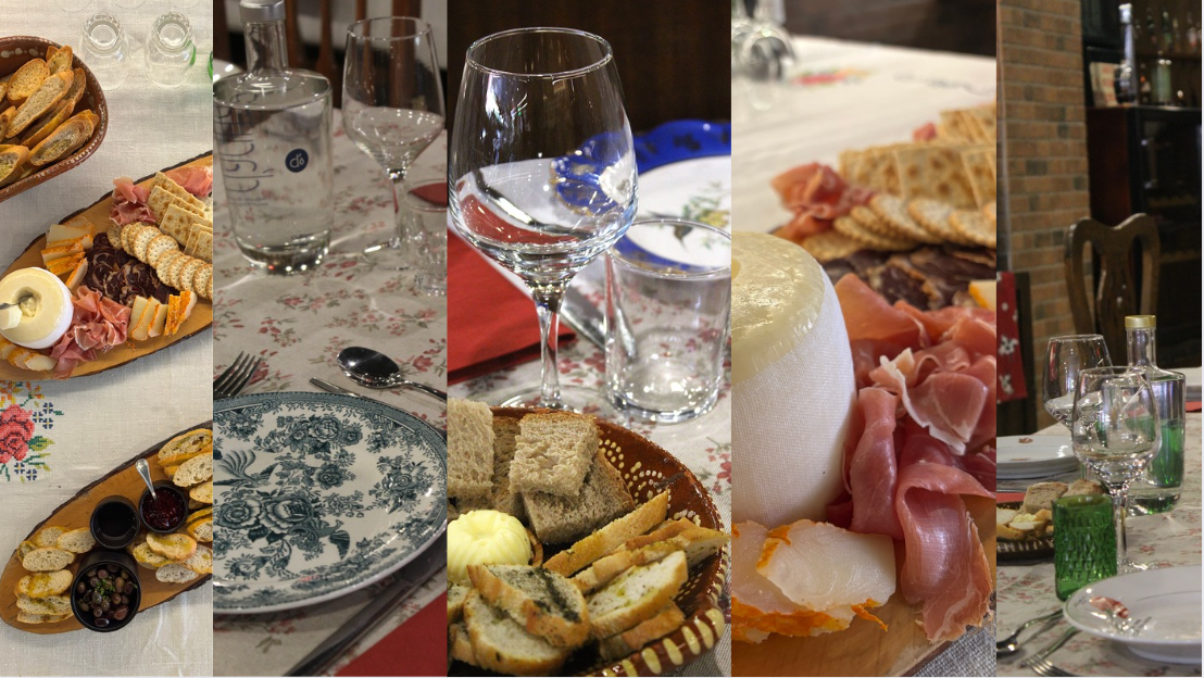 Eventos 1000 Paladares Mesa com pratos, taças, copos e tábuas de queijos e charcutaria para refeição.