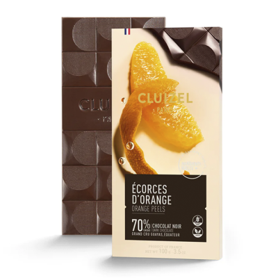 Barra de chocolate negro Cluizel 70% cacau com cascas de laranja na embalagem e barra de chocolate com padrão circular ao fundo