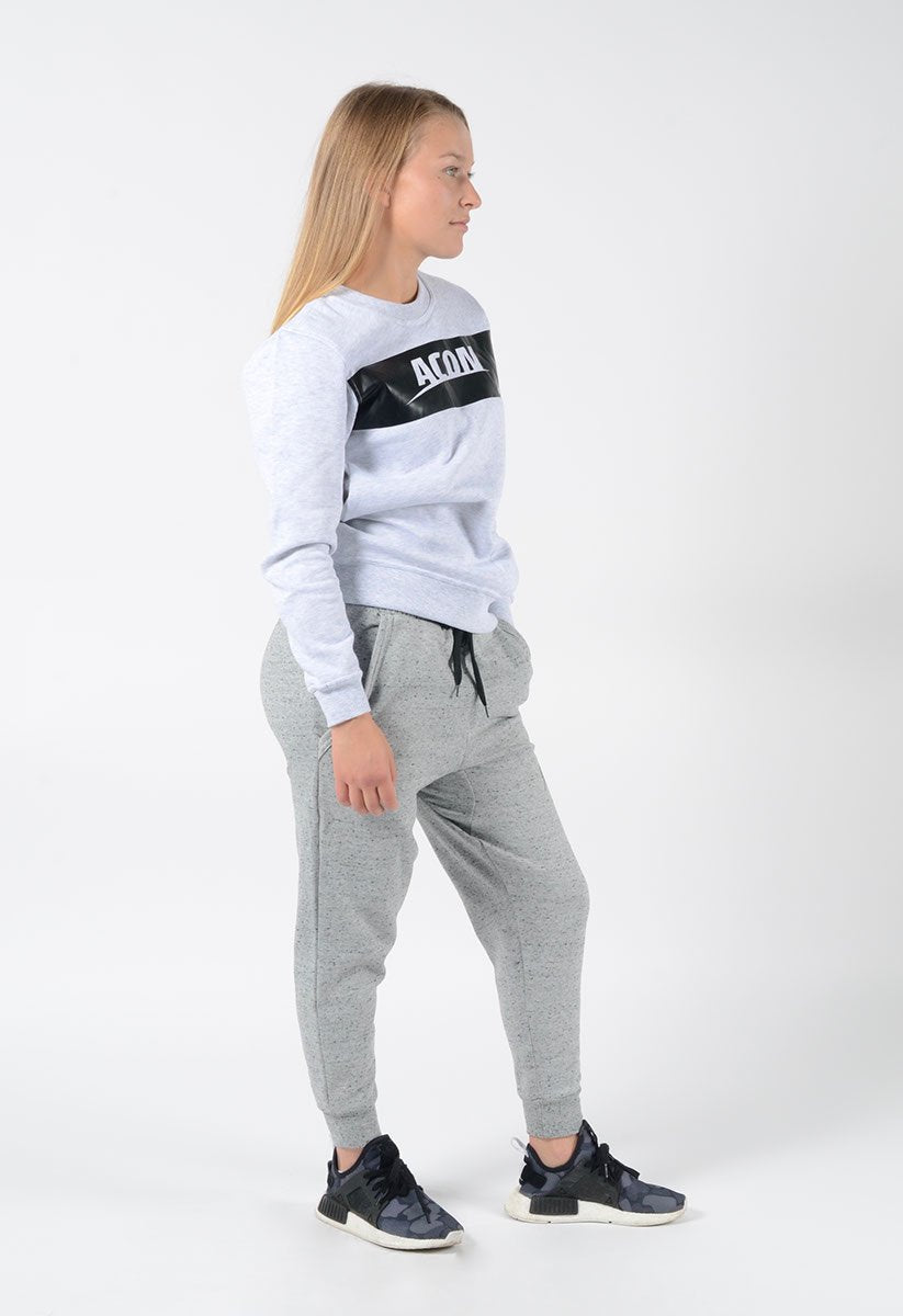 Mulher com roupa desportiva cinza e ténis camuflados