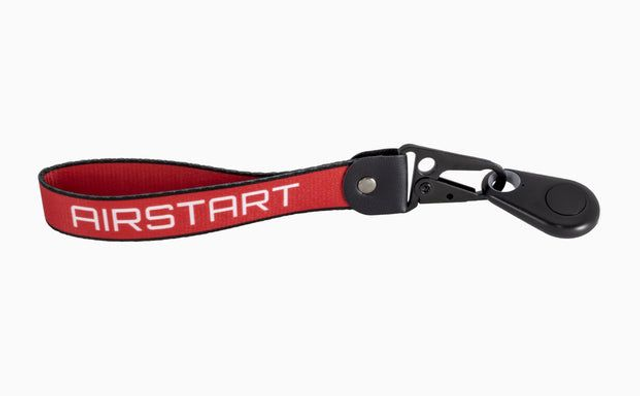 Chaveiro ou pulseira vermelha com texto AIRSTART e fecho preto